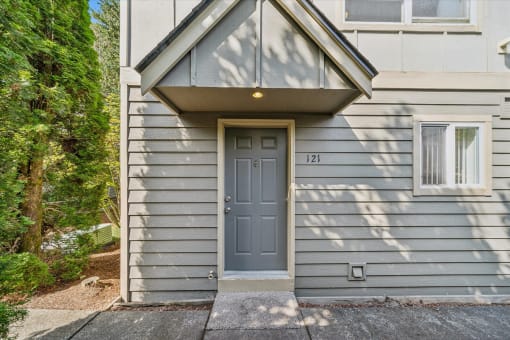the front of a blue house with a blue door