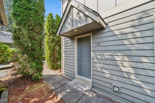 a blue door on the side of a house with a sidewalk