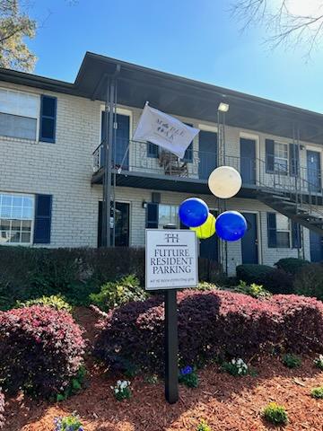 a sign in front of a building with balloons