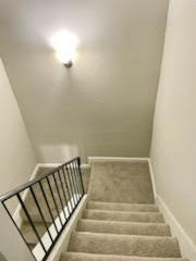 a staircase with a rail and a light on the ceiling