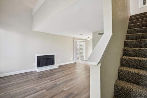 A room with a fireplace and a staircase.