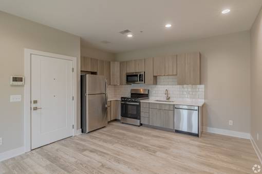 A kitchen with a refrigerator, oven, and microwave.