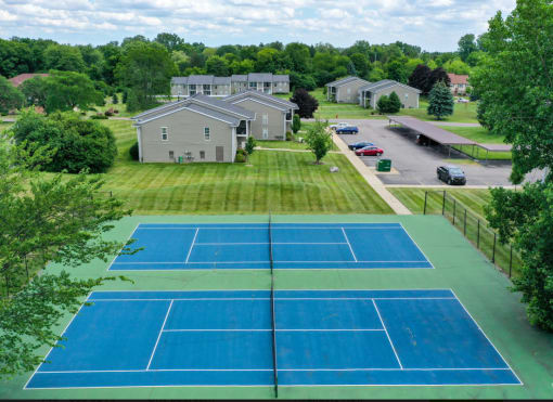 an aerial view of a tennis court with houses in the background