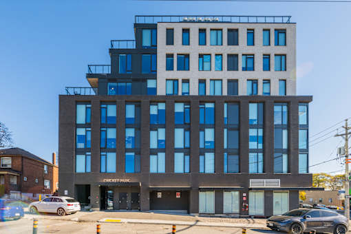 A modern building with a glass facade and a sign that reads "Cricket Park".
