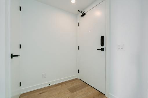 A white door with a black handle and a black lock.