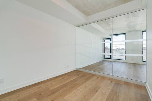 A room with wooden floors and a large mirror on the wall.
