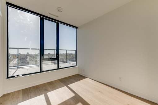 A room with a large window and a view of the city.