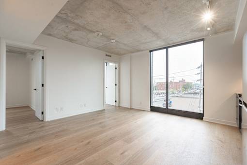A large empty room with wooden floors and white walls.