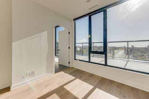A room with a view of the city through large windows.
