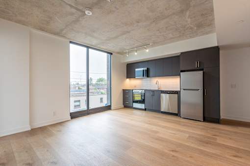 A kitchen with a refrigerator, microwave, and oven.