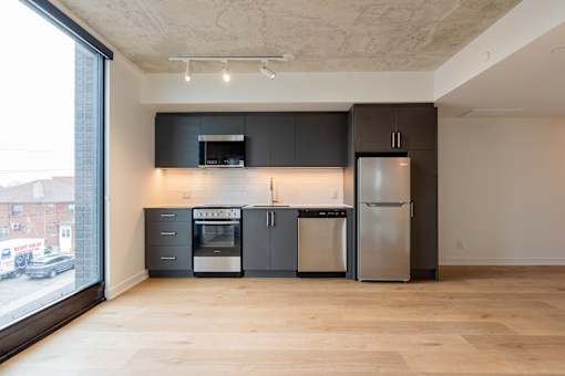 A kitchen with a refrigerator, oven, and microwave.