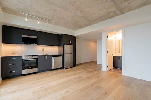 A kitchen with black cabinets and stainless steel appliances.