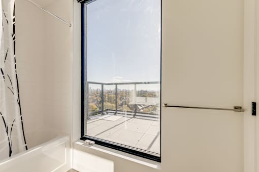A view of a parking lot from a window in a white room.