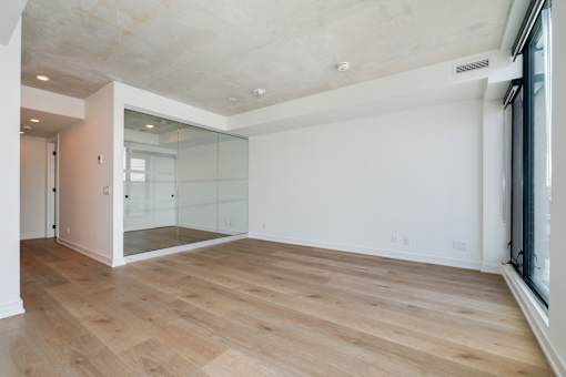 A room with wooden flooring and a glass wall.