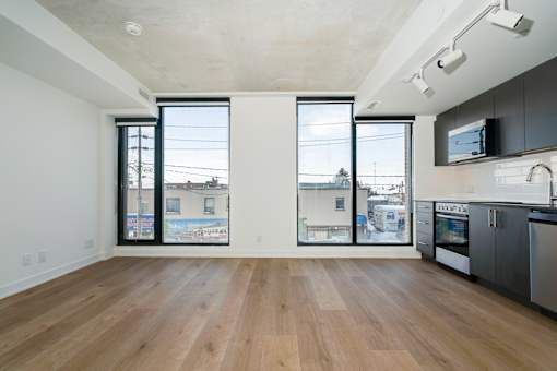 A kitchen with a wooden floor and a large window.