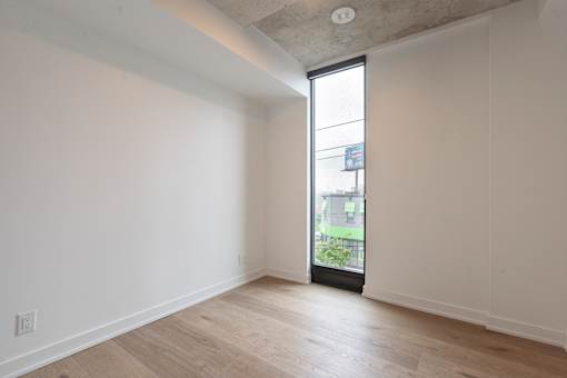 A room with a sliding glass door leading to a balcony.