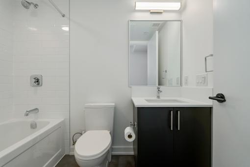 A white bathroom with a toilet, sink, and bathtub.