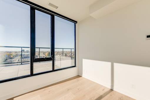 A room with a large window overlooking a parking lot.