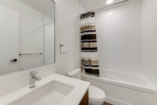 A white bathroom with a sink, toilet, and bathtub.