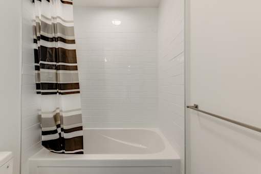 A white bathtub with a shower curtain in a bathroom.