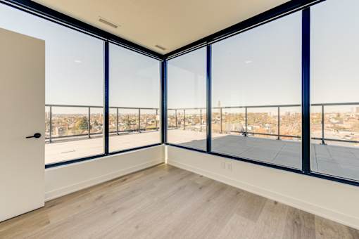 A room with a view of the city through large windows.