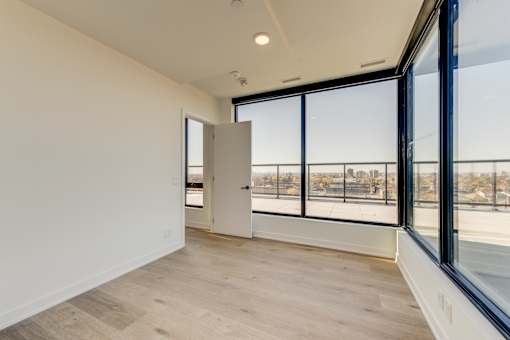 A room with a view of a cityscape through large windows.