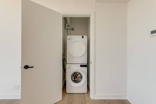 A white washing machine is in a small laundry room.