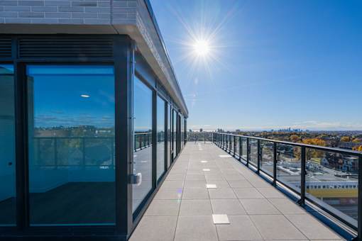 A sunny day on a balcony with a view of the city.