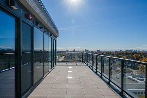 A sunny day on a balcony with a view of the city.