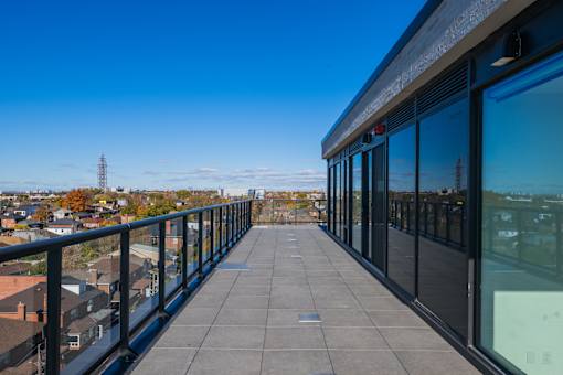 A balcony with a view of a cityscape and a tower in the distance.