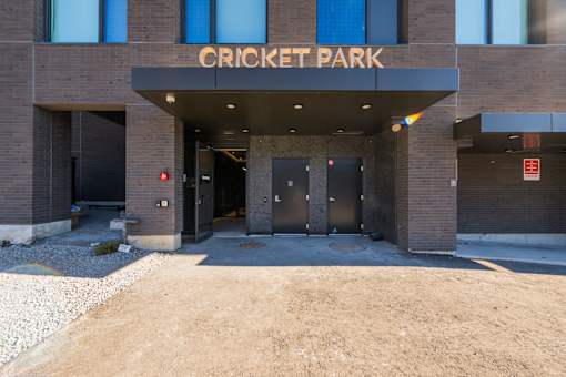 The front of a building with the words "Cricket Park" on it.