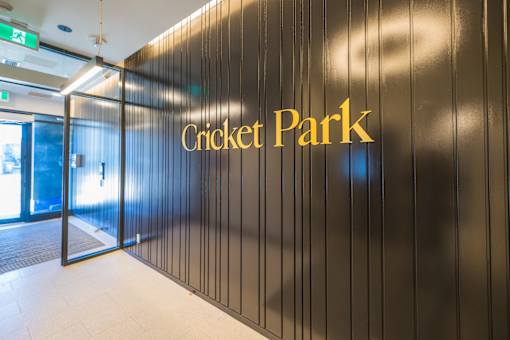 A wall with the words Cricket Park written on it.