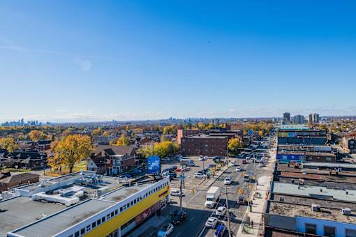 A city street with a yellow building on the left and a blue building on the right.