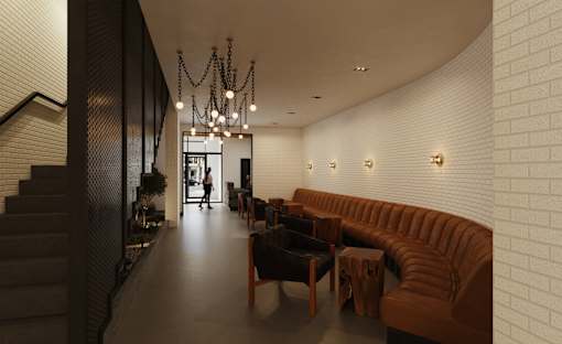 A long hallway with a brown couch and a chandelier.