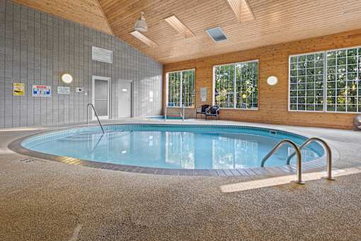 A round indoor swimming pool with a metal ladder.