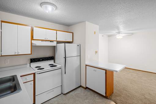A kitchen with white appliances and cabinets.