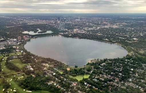 A large lake surrounded by a city and a golf course.