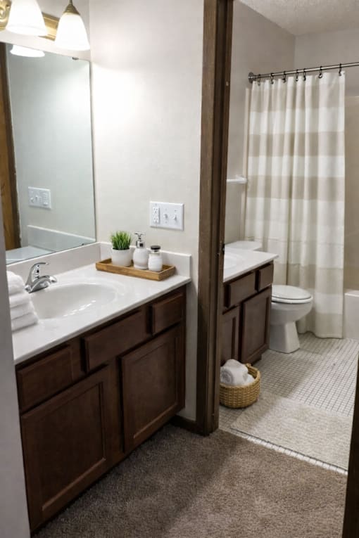 A bathroom with a white sink and a white toilet.