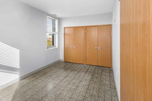 A room with a tiled floor and a window with blinds.