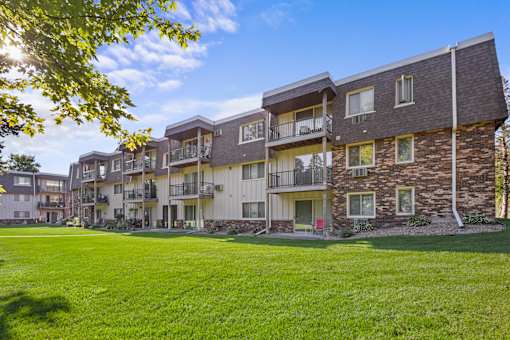 A sunny day at a grassy apartment complex.