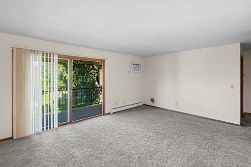A room with a sliding glass door leading to a backyard.