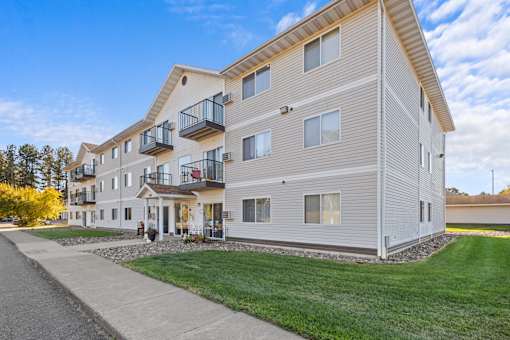A modern apartment building with a balcony on the second floor.