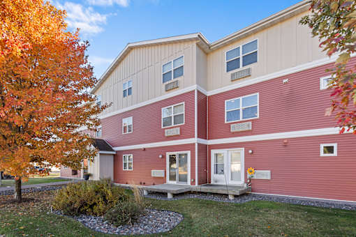 A red building with a tree in front of it.