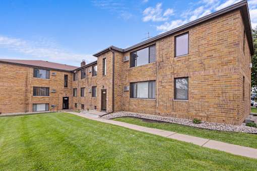 A brick building with a green lawn in front.