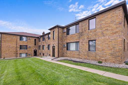 A brick building with a green lawn in front.