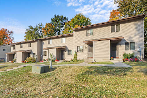 A row of houses with a grassy front yard.