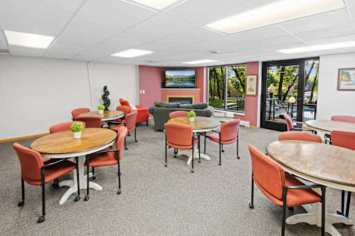 A conference room with a table surrounded by chairs.