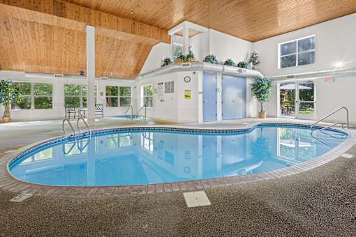 A large indoor swimming pool with a wooden ceiling.