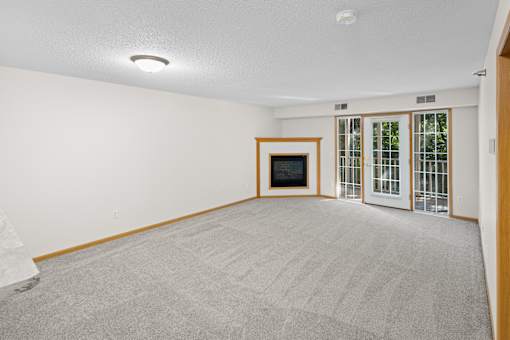 A room with a grey carpet and a white wall.