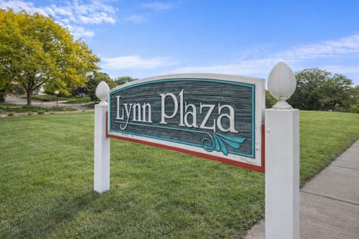 A sign that says Lynn Plaza stands in a grassy area.